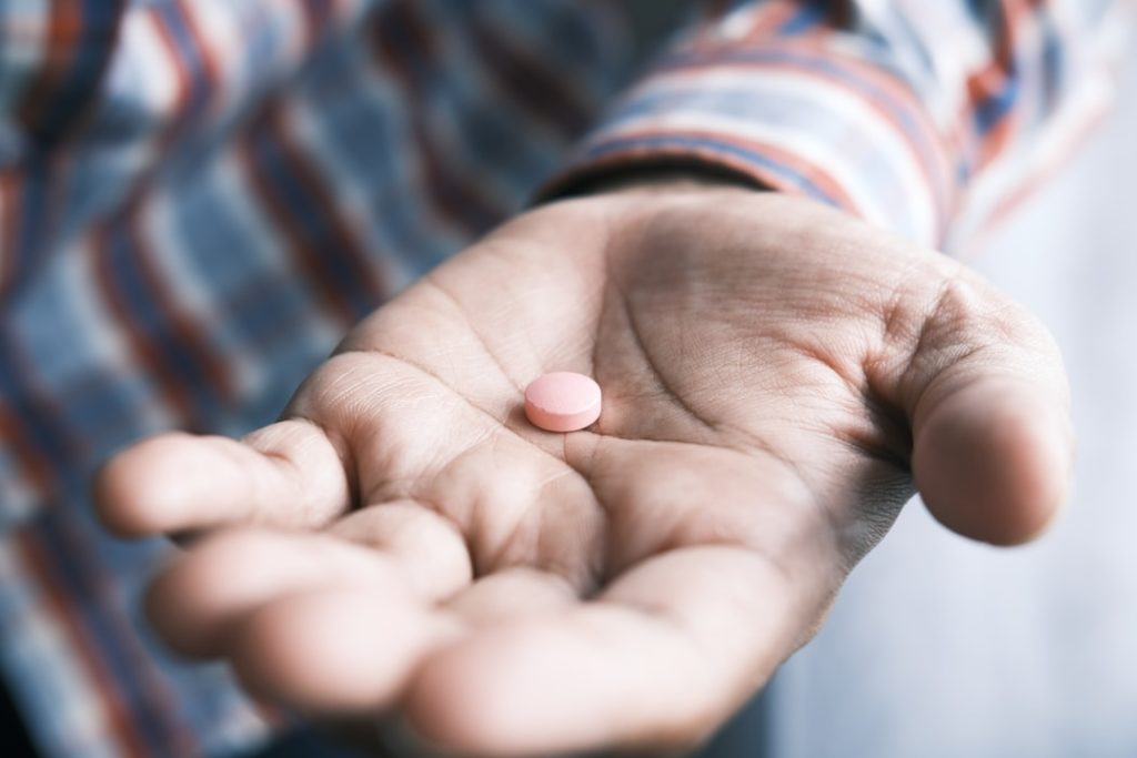 Image of a man eating a pill.
