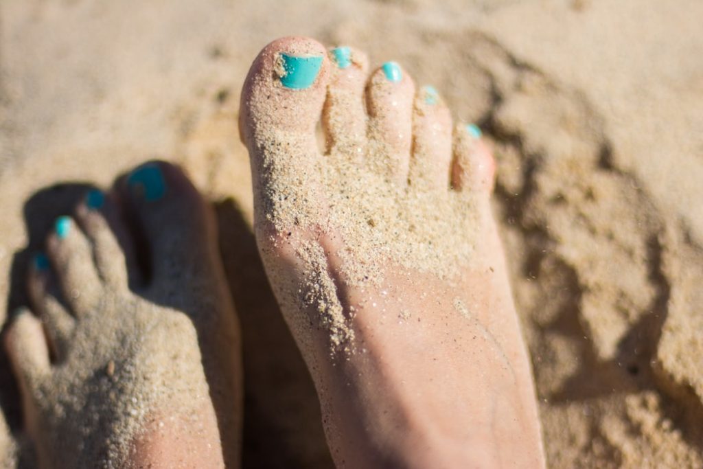 Image of feet covered in sand.