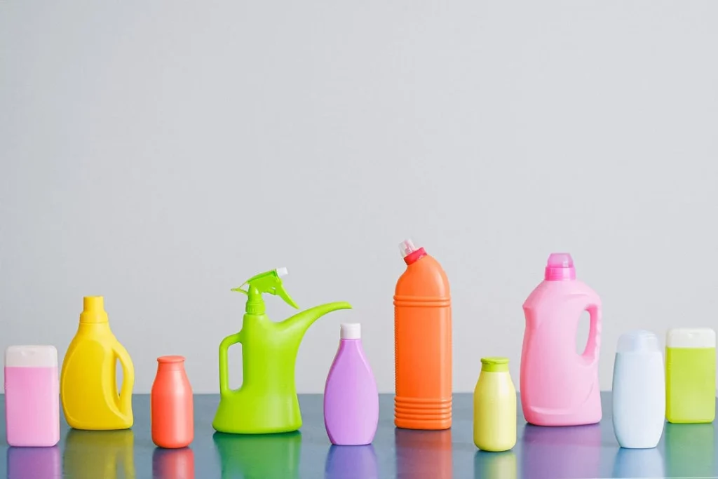 different shaped, sized, and colored spray bottles on a table