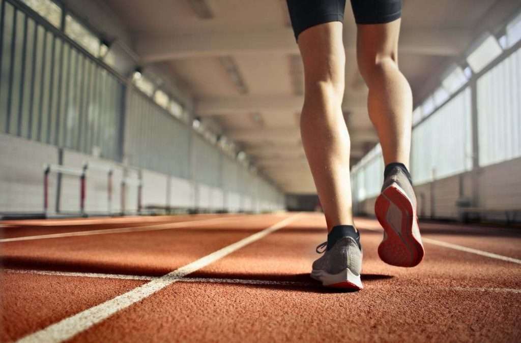 A photo of a person walking on a running track