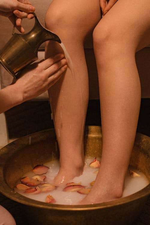 A Photo of a Person Washing Someones Feet at a Spa