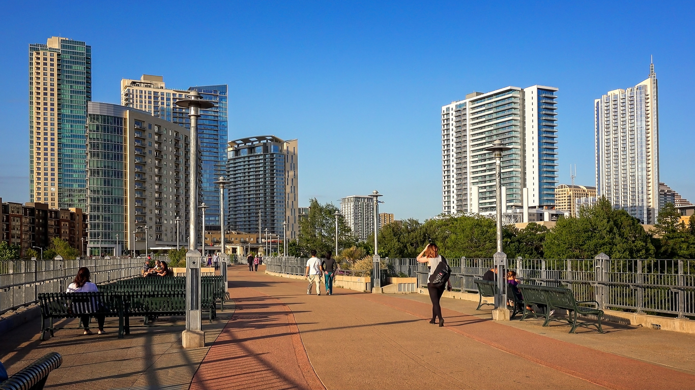 Pedestrians walking over pedestrian bridge to downtown Austin, Texas